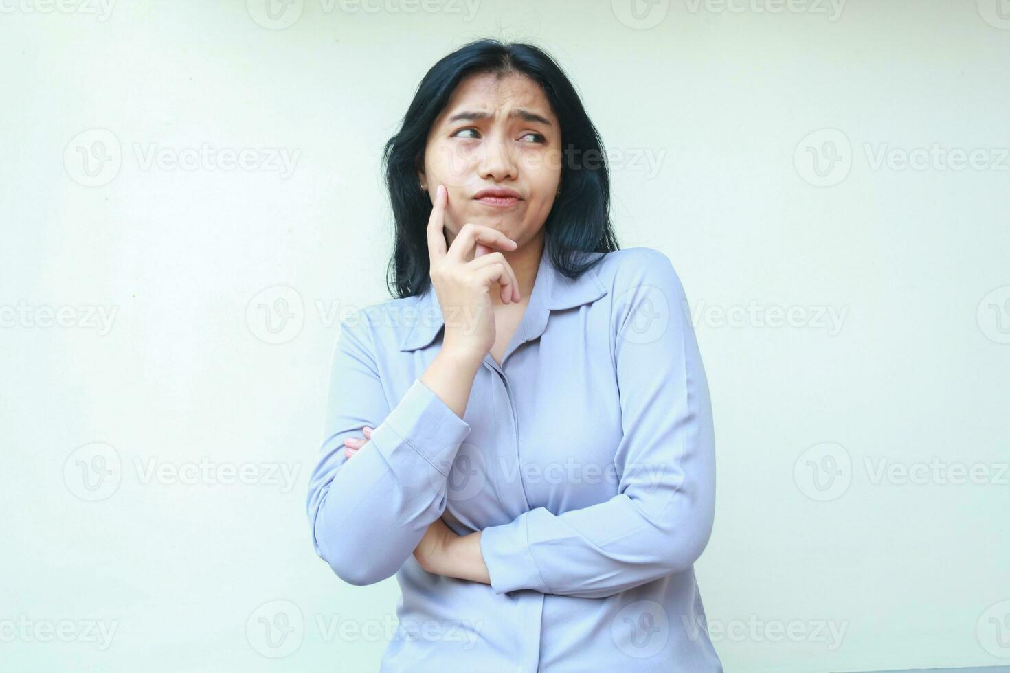 pensive pretty asian young woman thinking solution idea looking away keep arm folded with forefinger touch her cheek wear formal suit isolated photo
