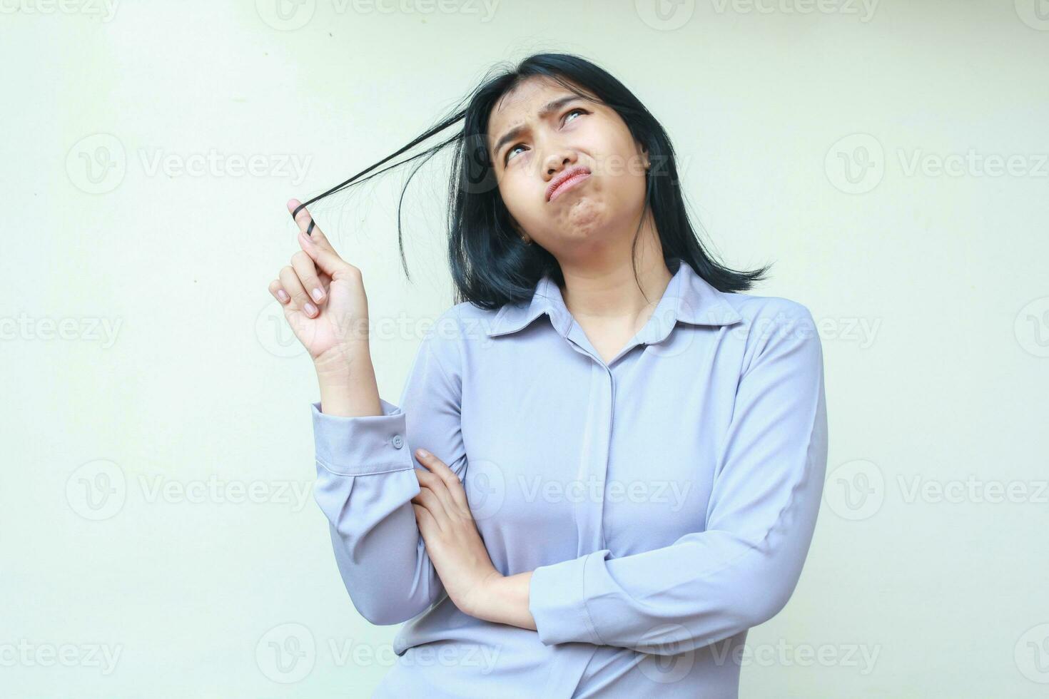 concerned beautiful asian young woman isolated on white background looking above puzzled with wondering and curious expression, female dressed in formal suit photo