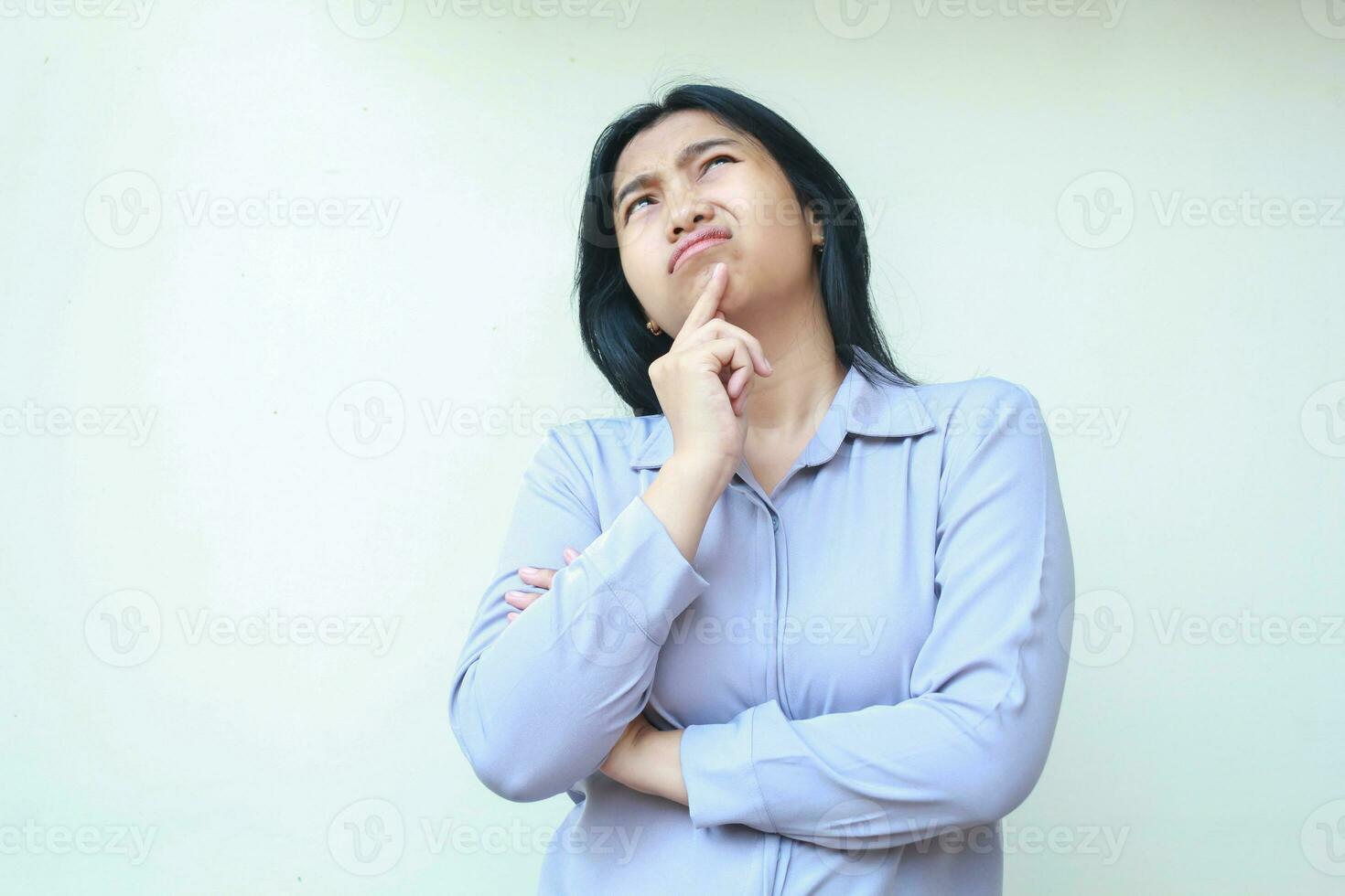 beautiful asian business woman thinking wondering with hand on chin and folded arm looking above wear formal shirt isolated on white background photo