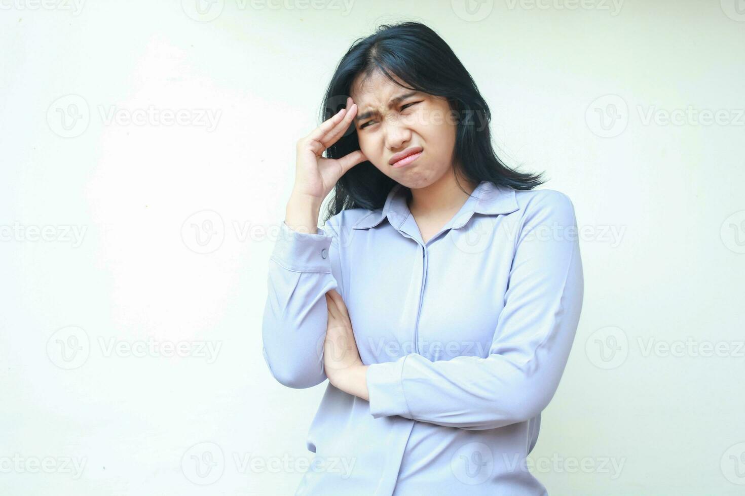 overworked asian woman stressed touching head have migraine with arm folded wear formal suit looking down isolated photo