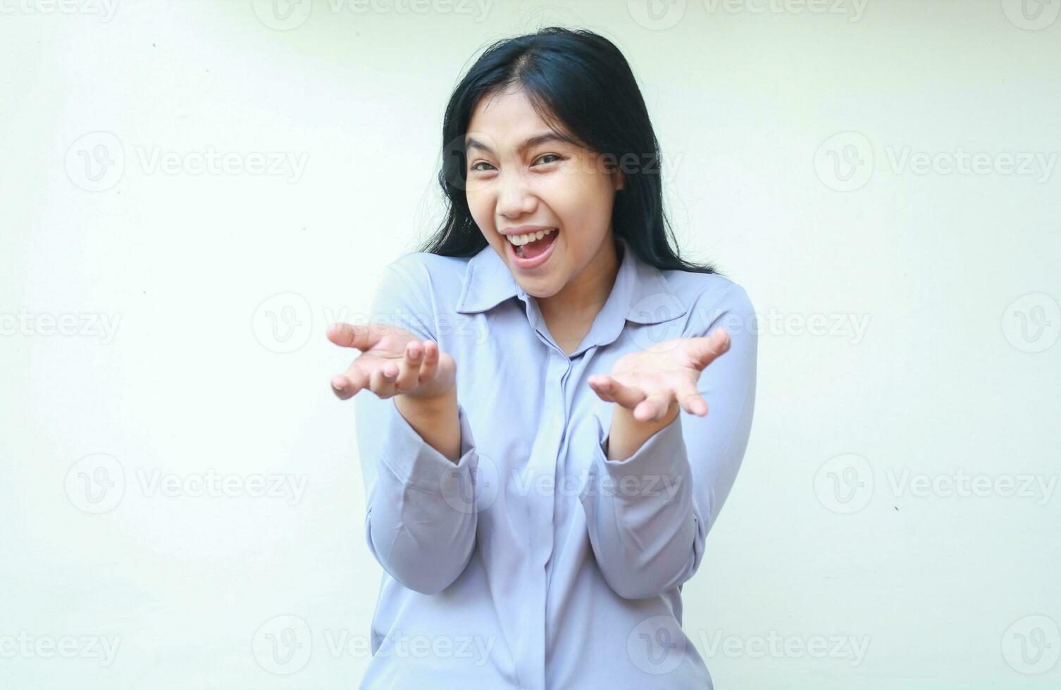 smiling excited asian young woman presenting to camera with open palm, introducing pose female look at camera, isolated by white background photo