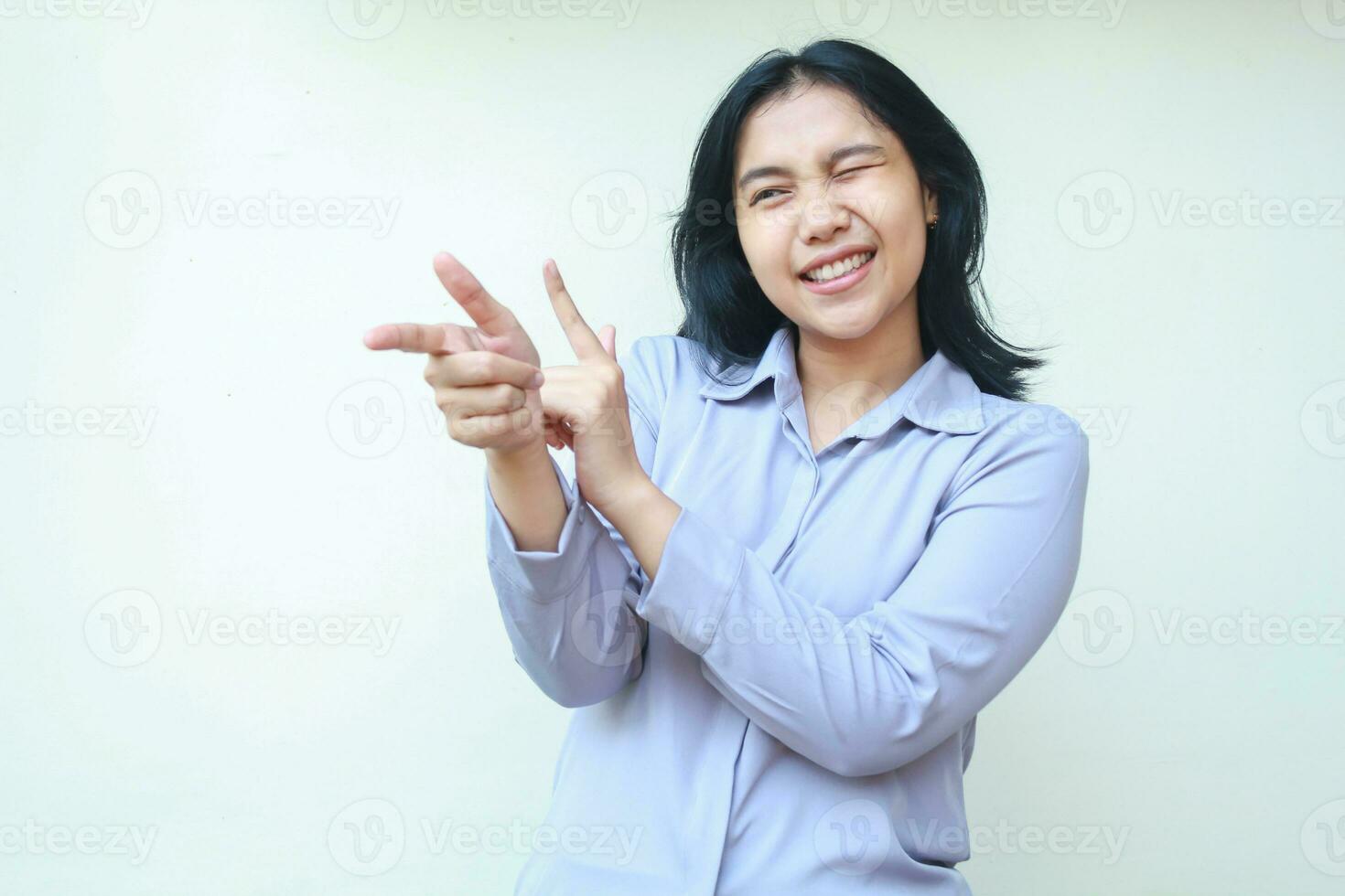 image of smiling beautiful young business woman manager pointing finger and blink eye excited to introduce product, wear formal shirt, isolated over white background photo