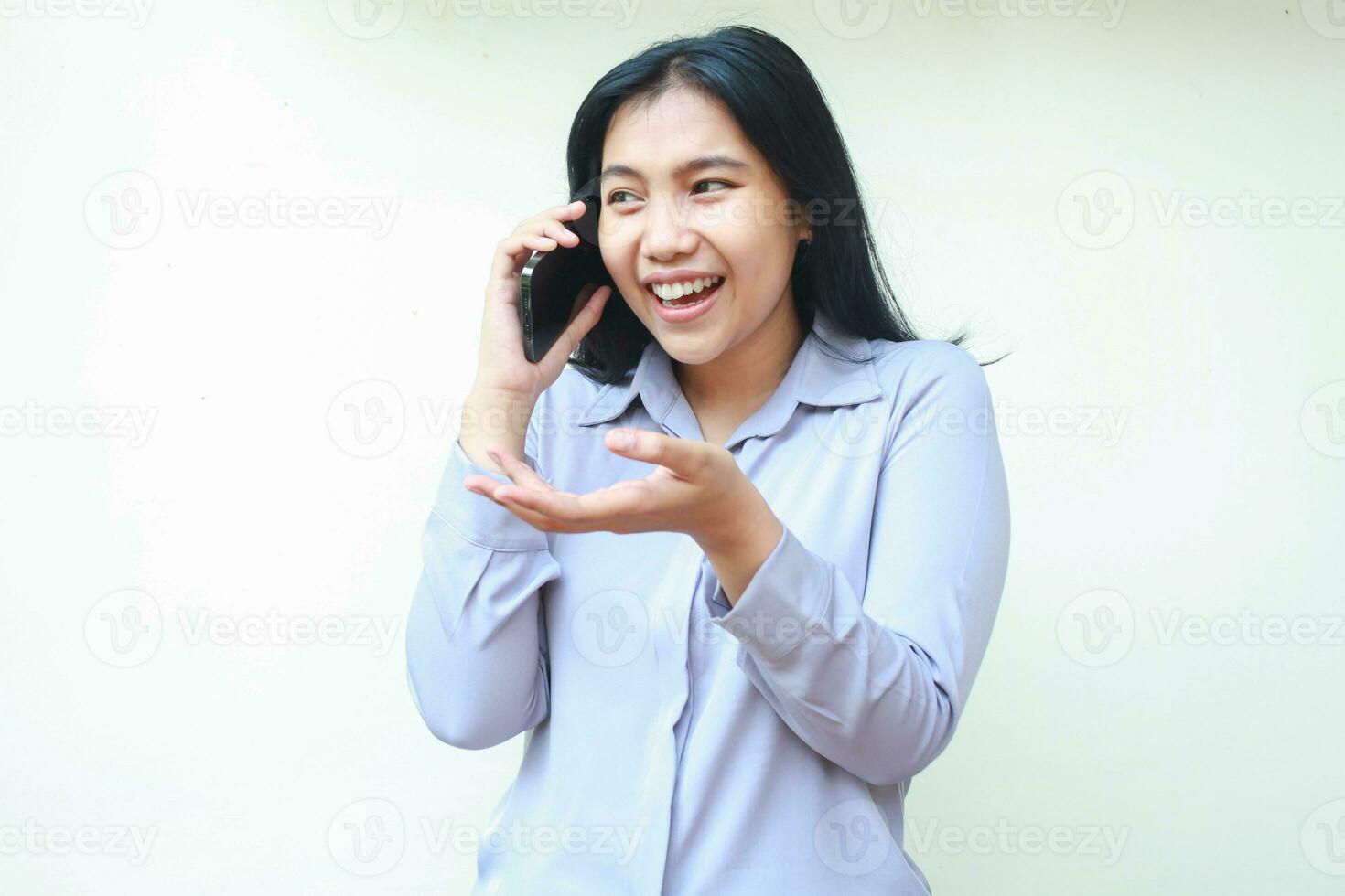 carefree asian young asian business woman excited to make a call to speaking on cell phone with presenting and questioning gesture, wear formal suit isolated in white background photo