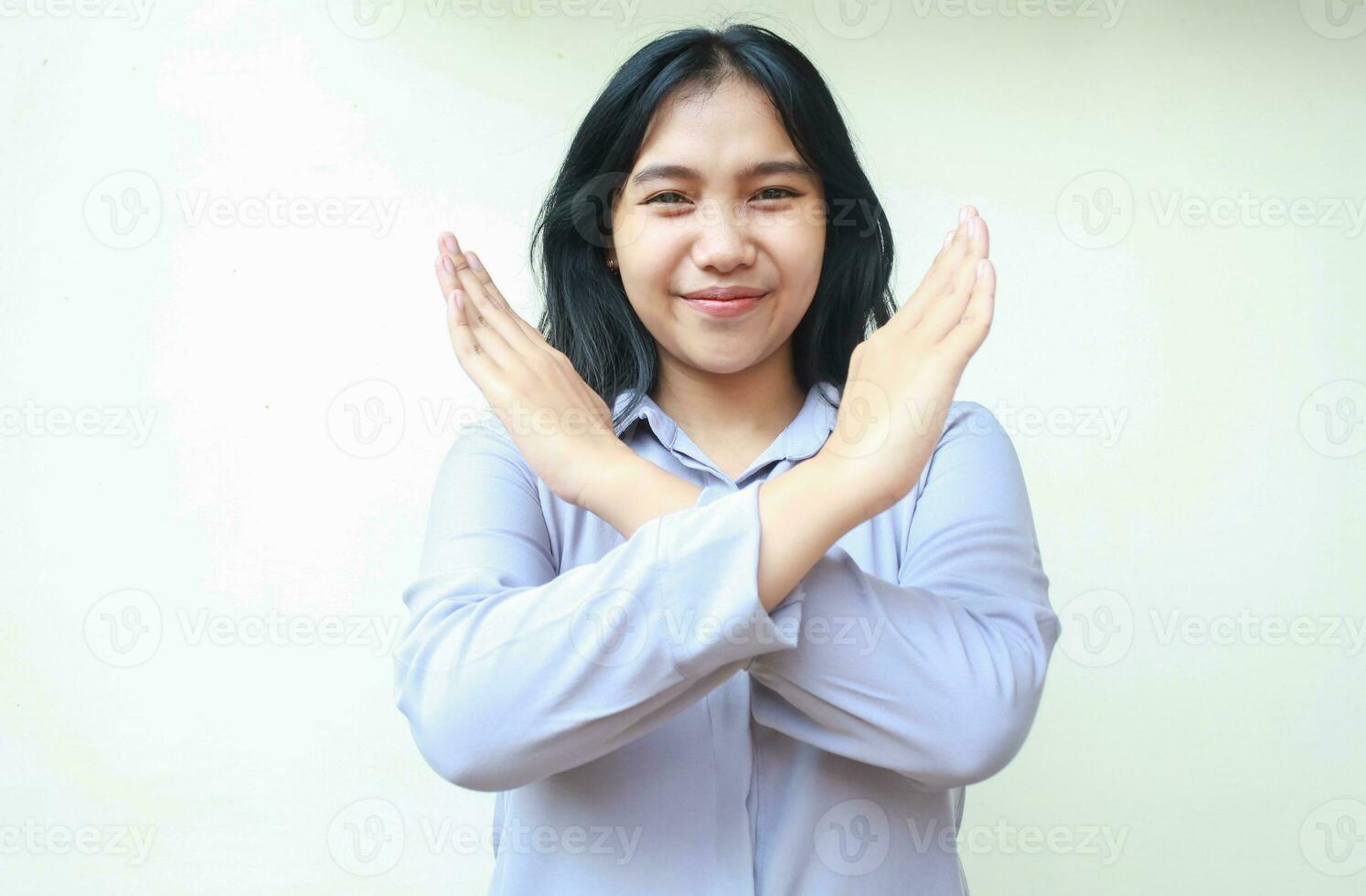 studio shot of peaceful asian young business woman crossing arm as stop symbol wearing formal office clothes standing over white background, look at camera photo