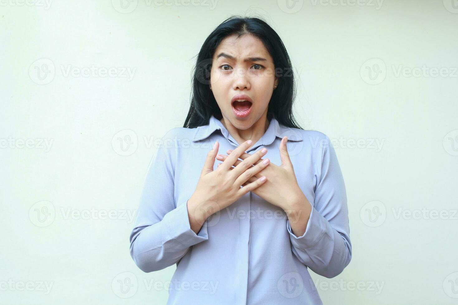 shocked asian young woman wearing formal office clothes stunned looking at camera with open mouth and hands on chest, standing over isolated white background photo