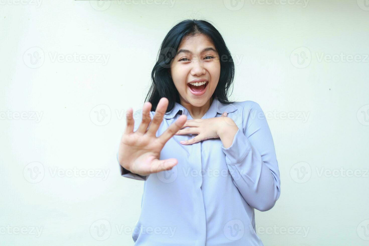 studio shot of stunned asian young beautiful business woman reaching hands towards camera smiling amazed wearing formal office shirt standing over isolated white background photo