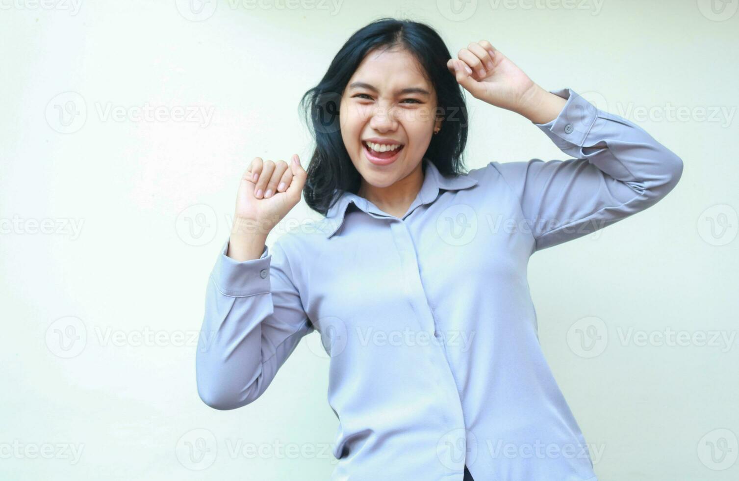 enthusiastic pretty asian young business woman raising fist pump say yes gesture look at camera, celebrating victory, winning and achievement with dance wear formal shirt isolated on white background photo