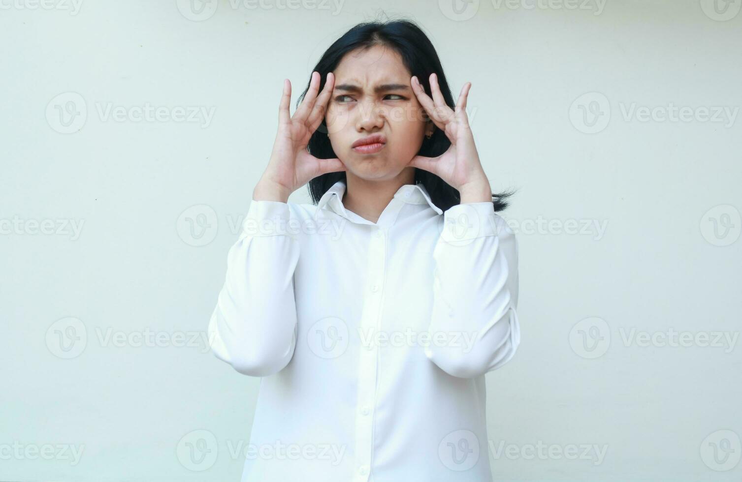 portrait of asian young business woman manager looking away confused with two palm on face, thinking problem solution, bored facial expressive, standing wearing white formal shirt photo