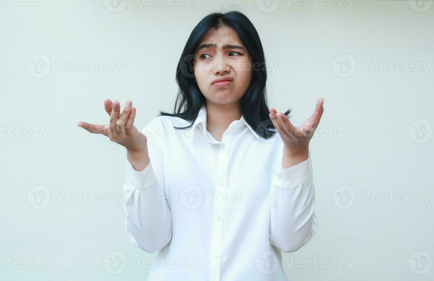 what happens. portrait of confused asian business woman manager thinking problem solution with shrugging shoulders raise arm keep palms sideways looking away photo