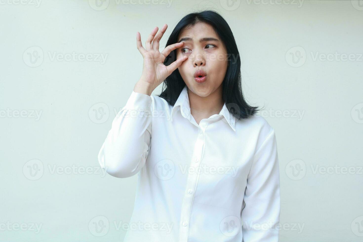 thoughtful asian young woman looking away daydream, surprised open her eye with fingers showing wow expression, wearing white formal suit shirt isolated photo