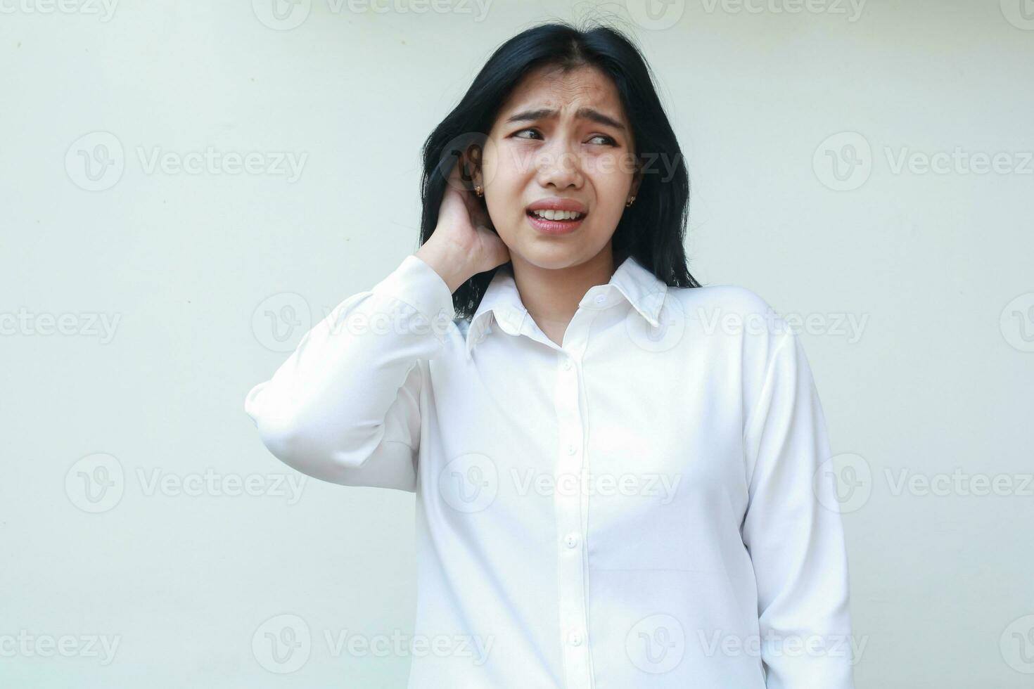 imagen de ansioso asiático joven negocio mujer vestido en blanco formal traje camisa agarrando su oscuro pelo Mira lejos atemorizado, sensación cansado de con exceso de trabajo, lamentándose errores ella hecho porque problema foto