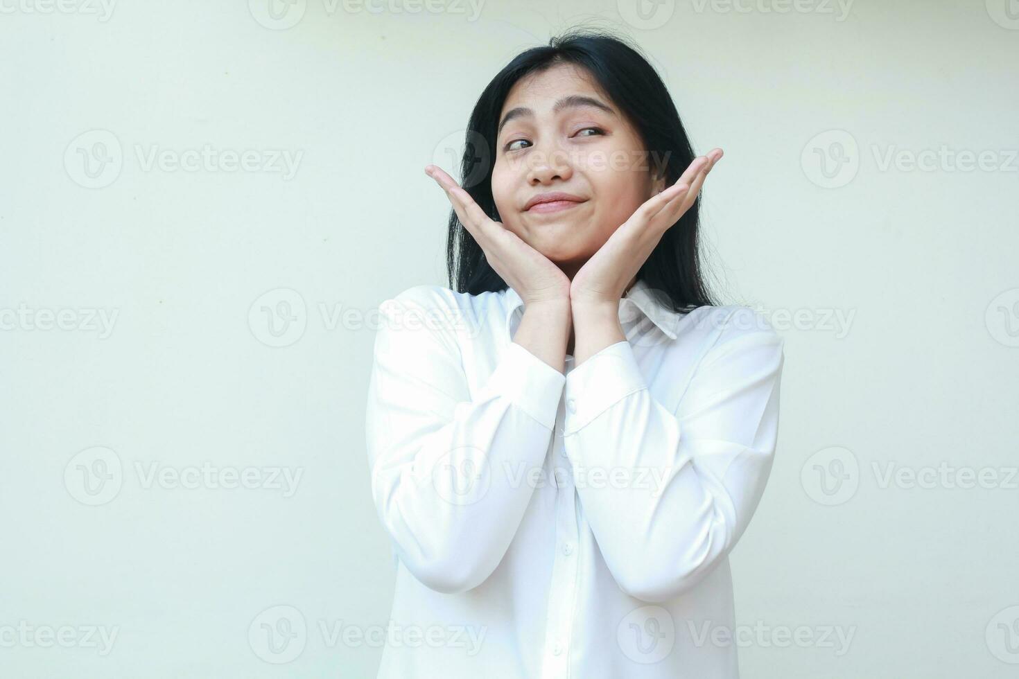 image of cute asian young business woman thinking about something with two palms on chin looking away wondering happy, wish me luck gesture, hoping good things expression photo