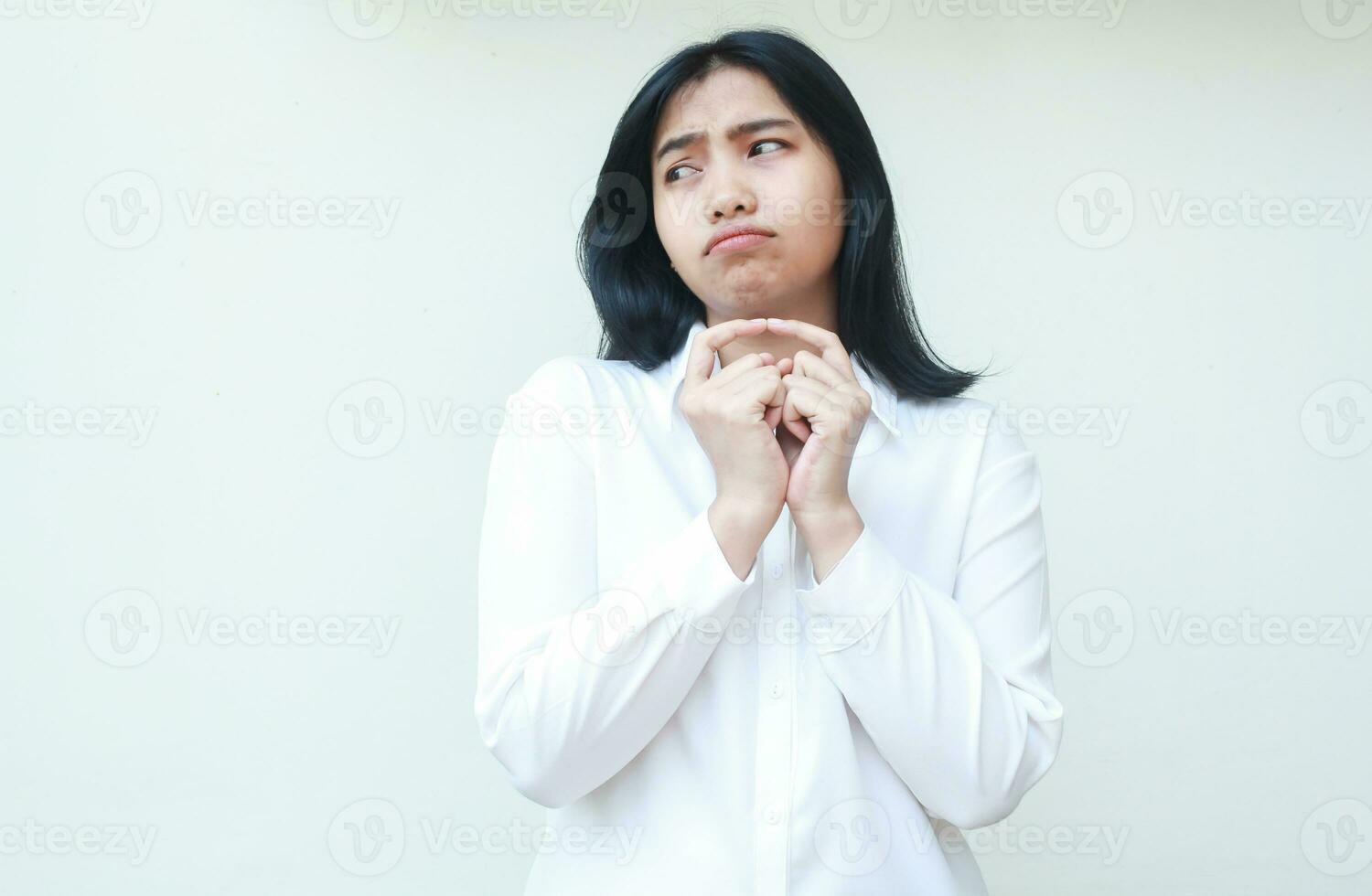 thoughtful cute asian business woman stick forefinger together show sad demanding expression looking away to empty space wearing white shirt formal suit, depressed of overtime job, standing isolated photo