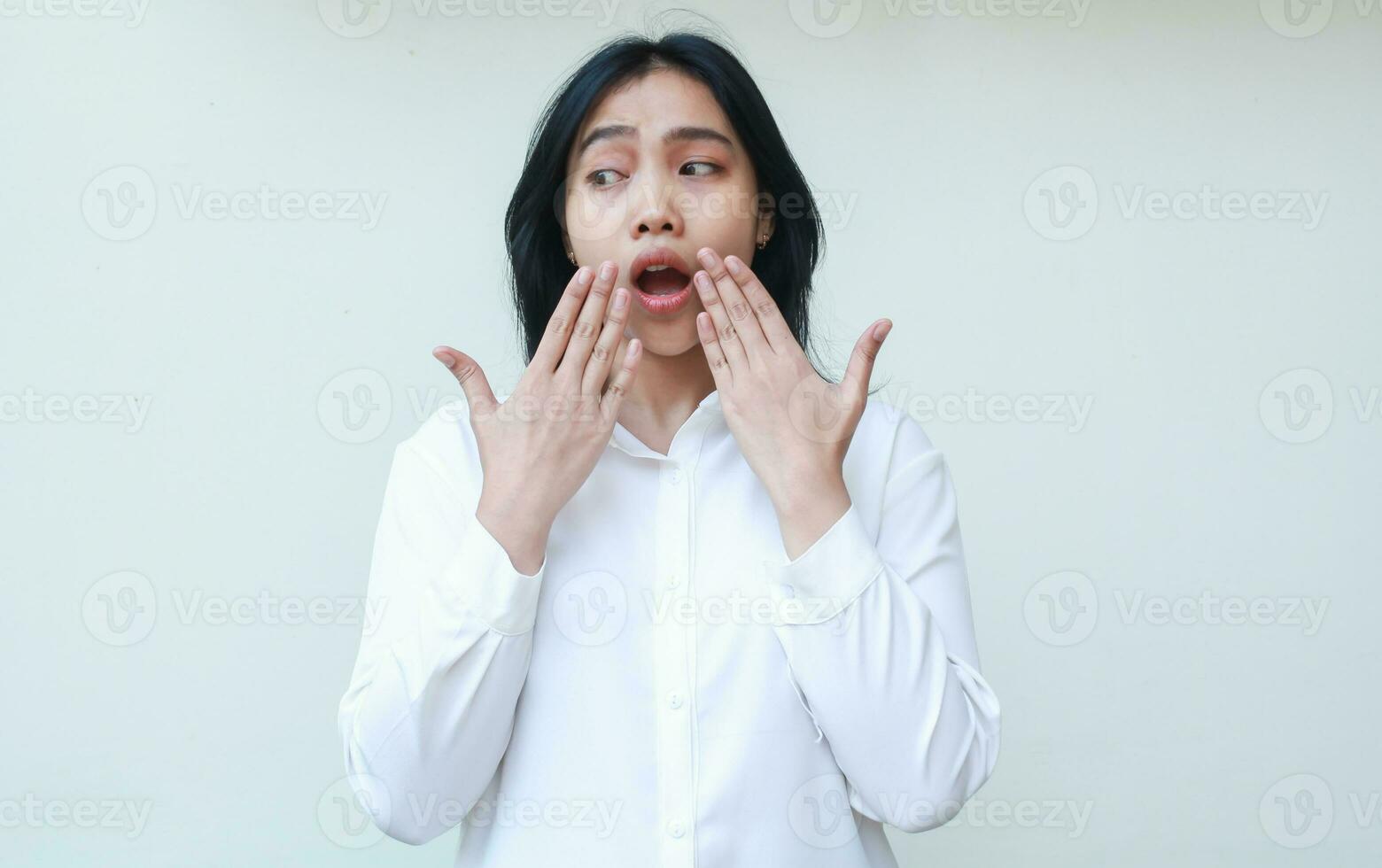 portrait of shocked asian business woman covering mouth open wide with hands looks looks panic and scared wearing white shirt formal suit standing over isolated background photo