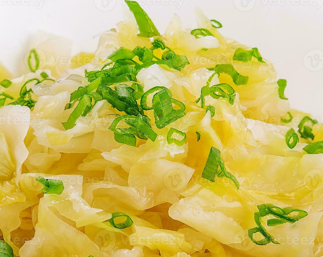 Bowl of tasty fermented cabbage on white photo