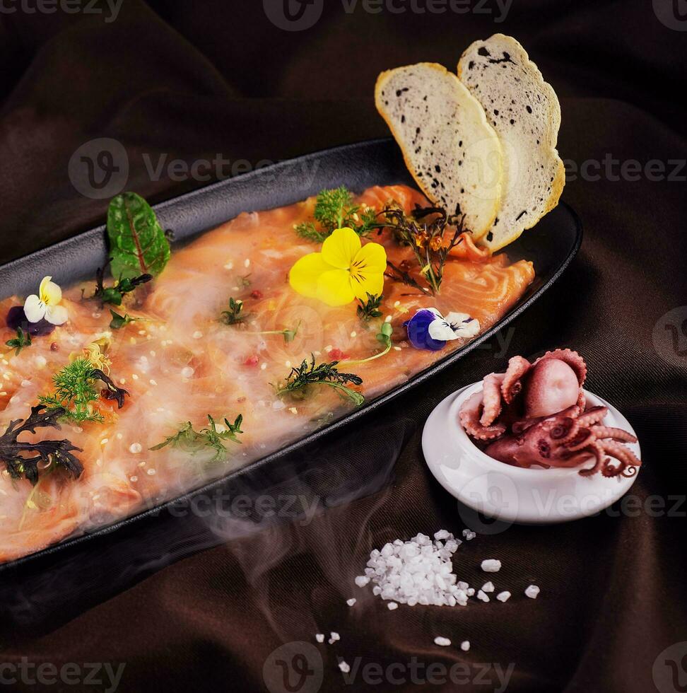 Smoked salmon carpaccio and octopus with white smoke of liquid nitrogen photo