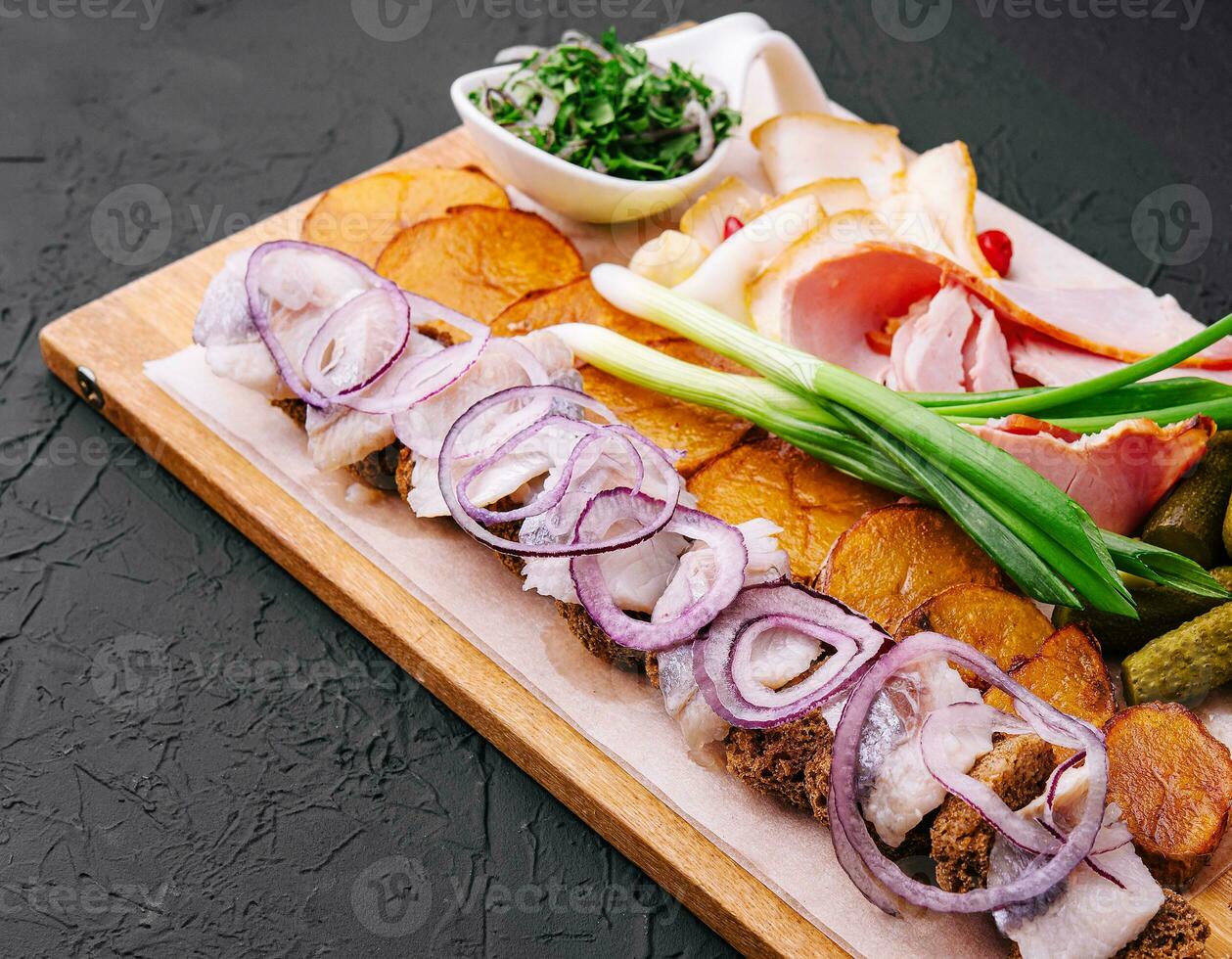 Rustic appetizer for vodka on wooden board photo