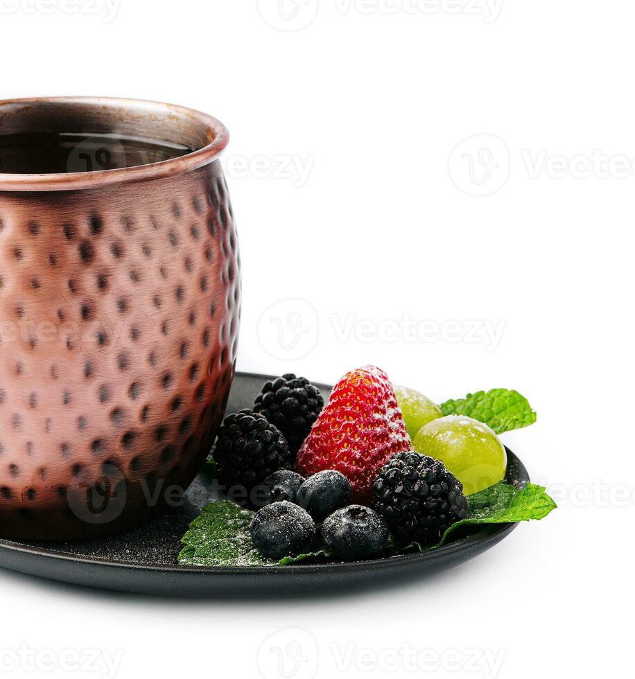 metal camp mug with tea with berries photo