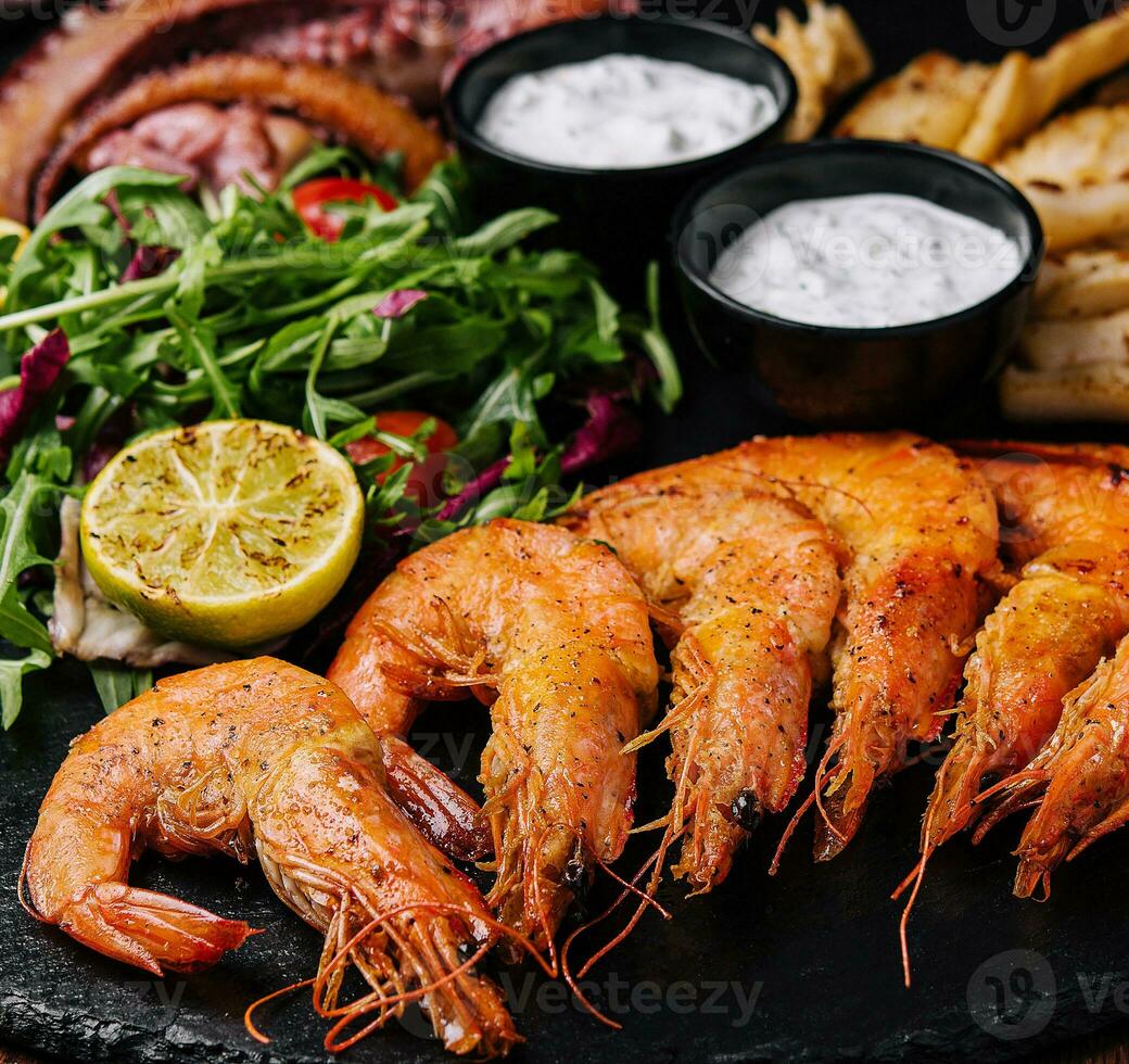 Traditional greek grilled seafood on restaurant wooden plate photo