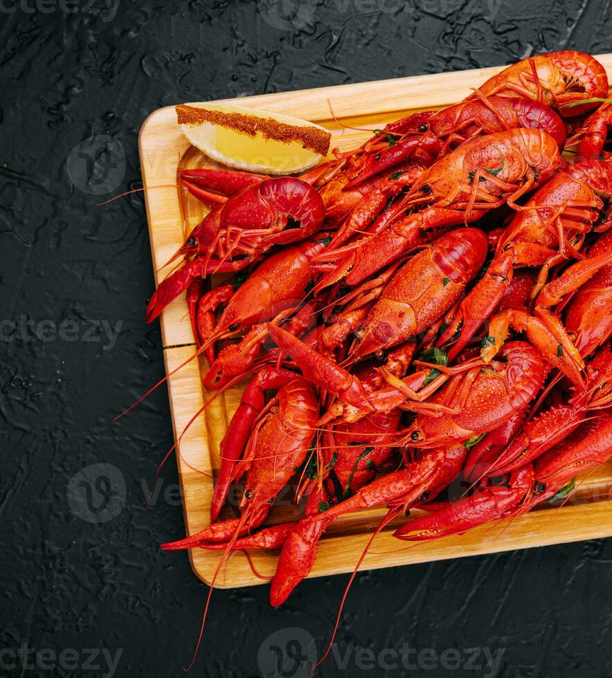 Fragrant boiled crayfish on a wooden board photo