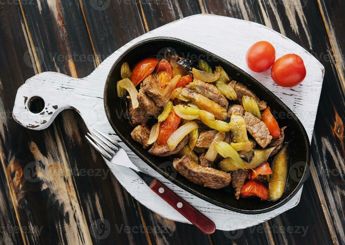 un plato de asado carne, estofado vegetales en madera foto