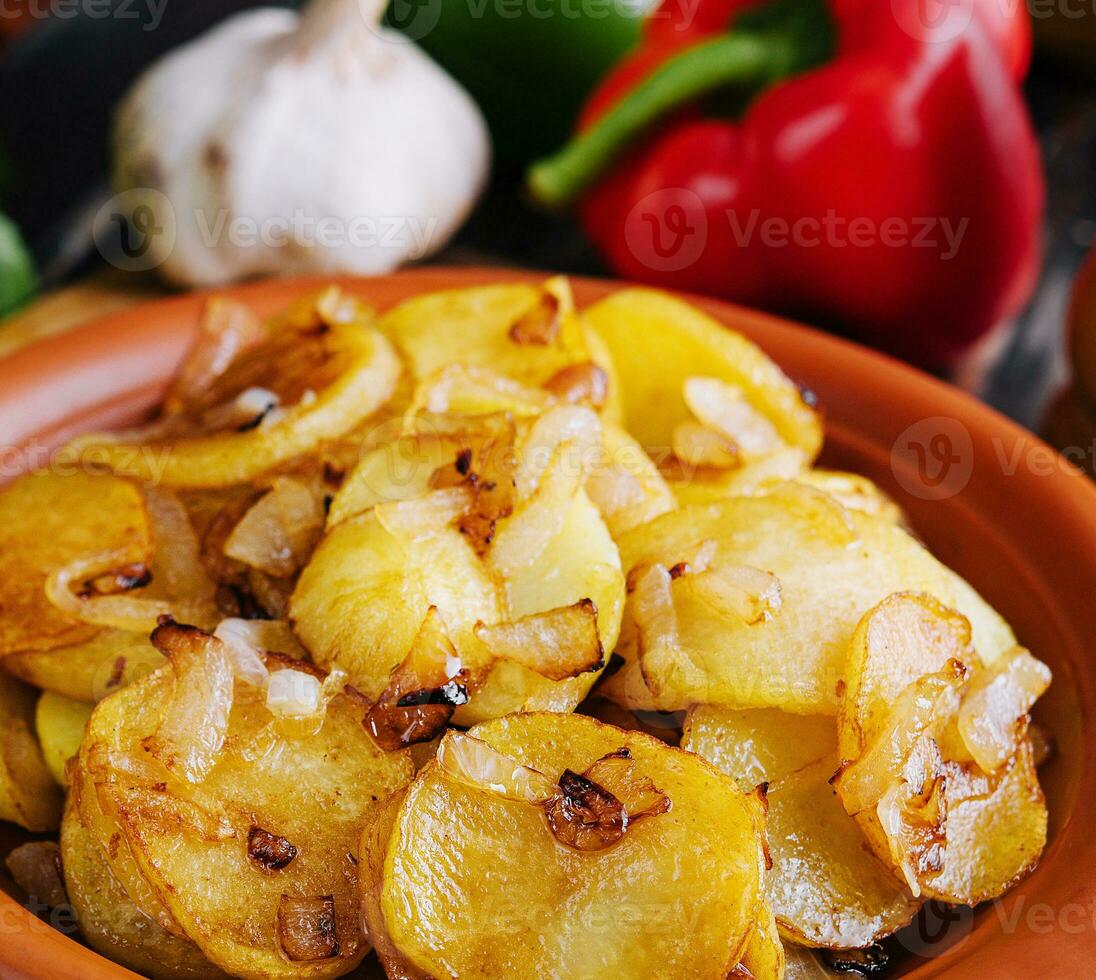 frito patatas con cebollas en de madera bandeja foto