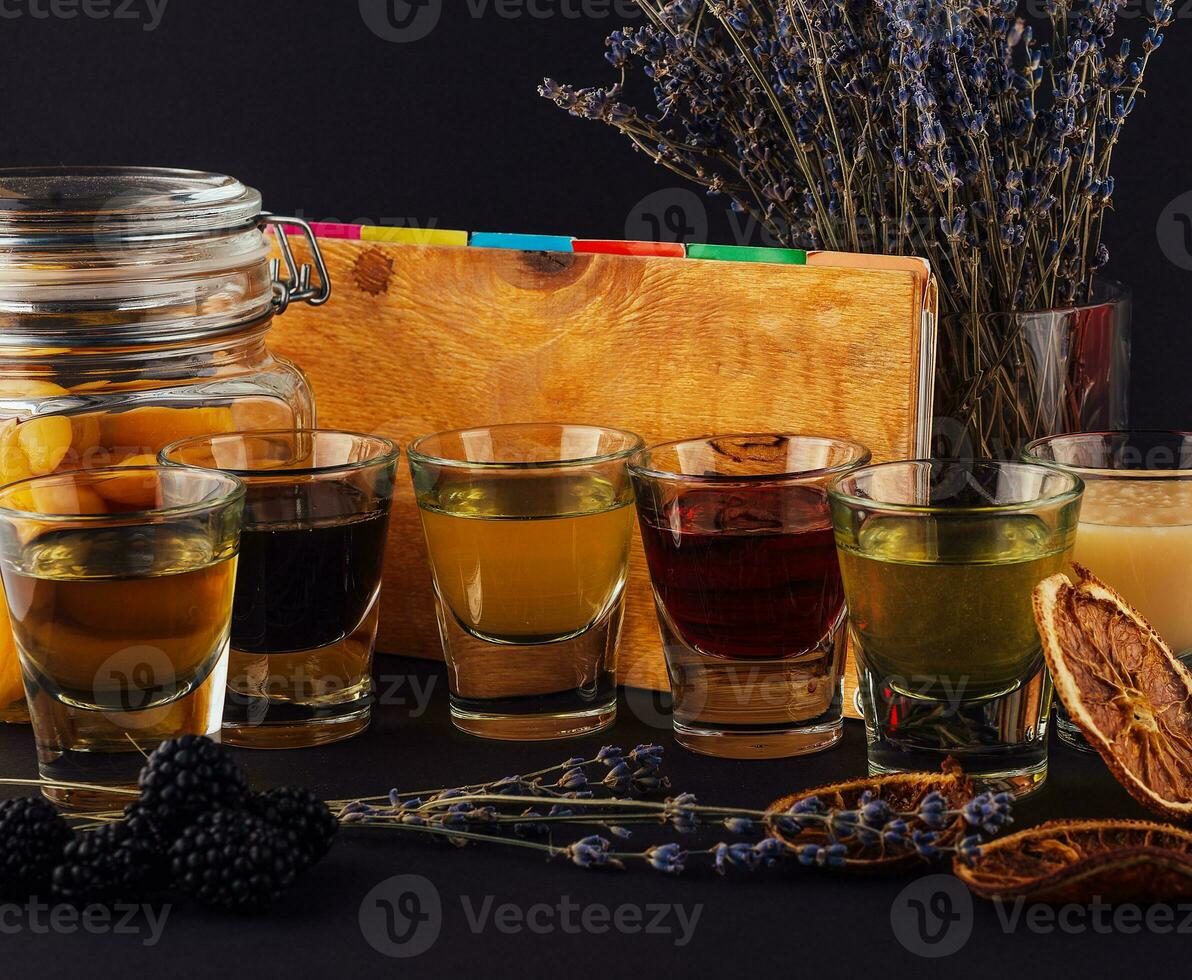 Multicolored transparent cocktails, a set of shots in one row photo