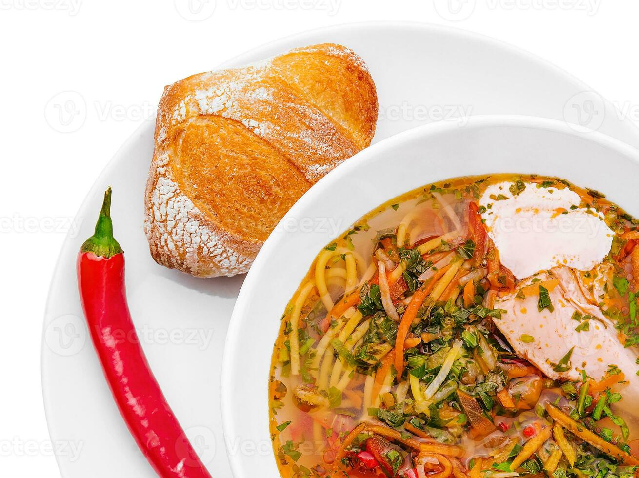 Chicken soup with noodles and vegetables in white bowl photo