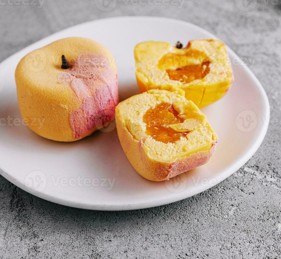 Two small french mousse cake apple shaped dome served on a plate photo