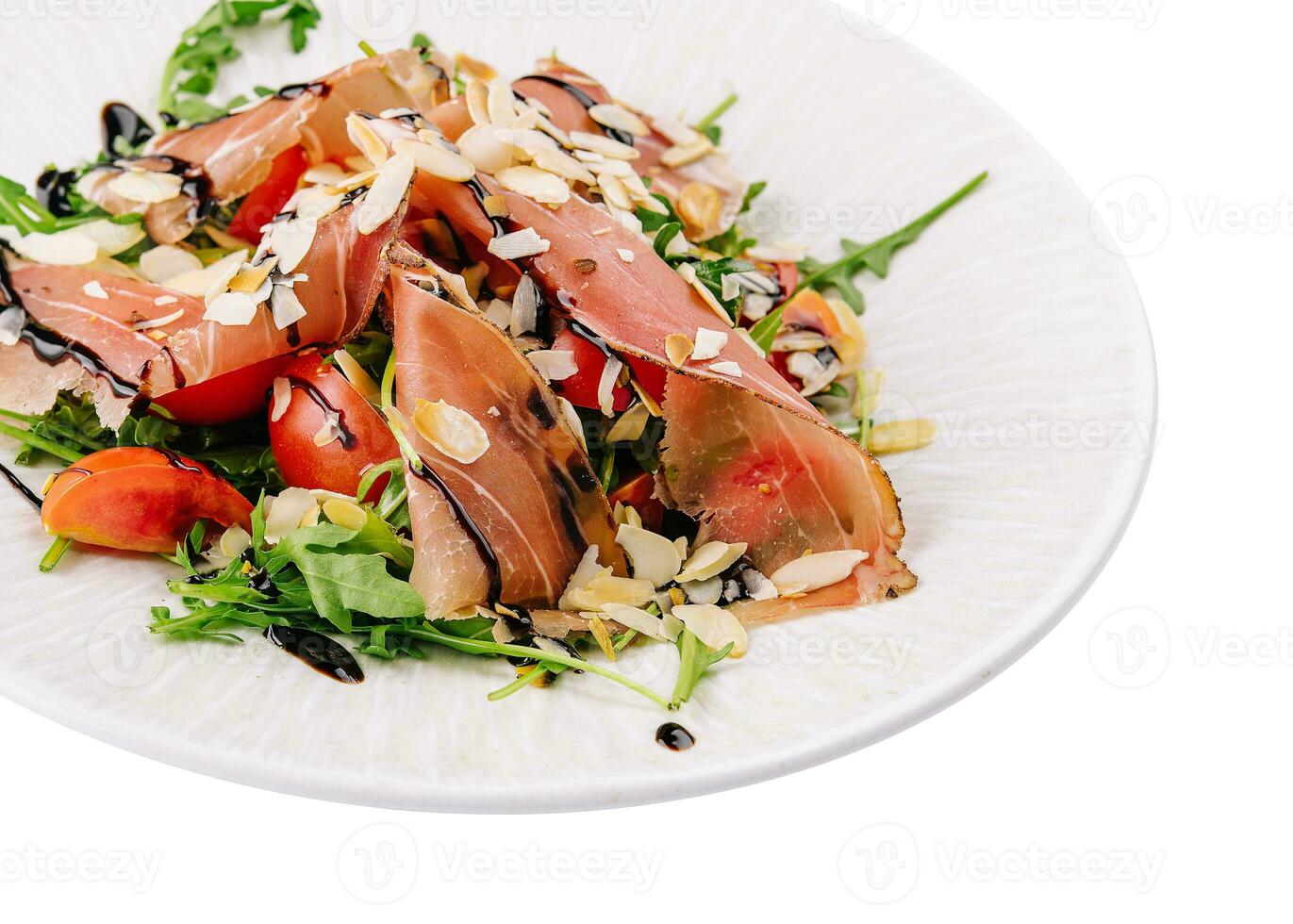 Salad with prosciutto, tomato, arugula leaves on plate photo