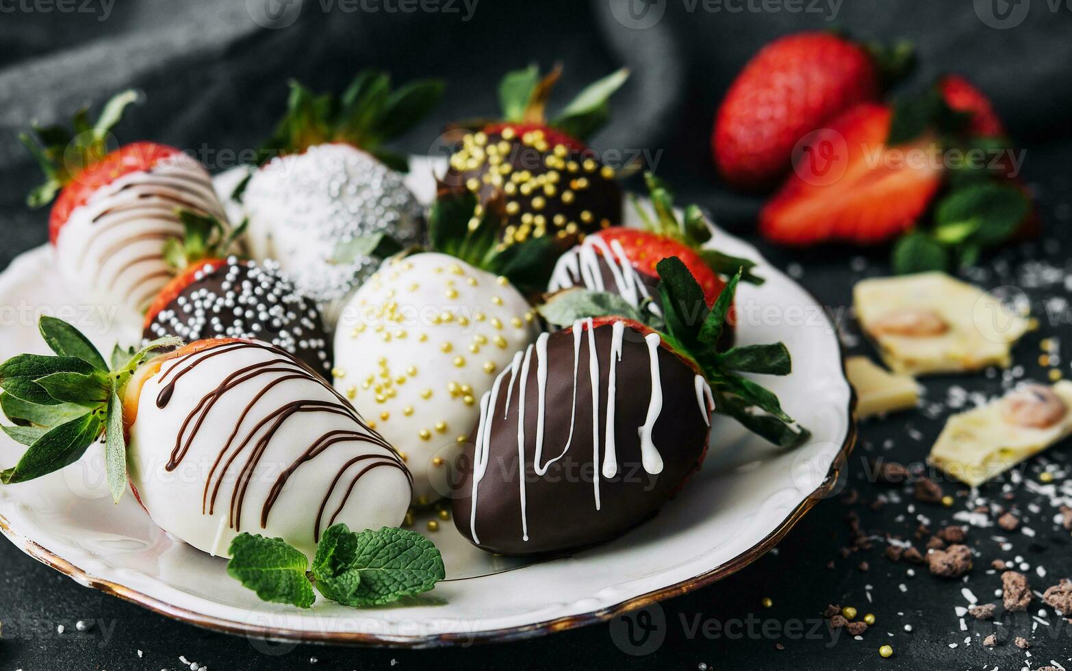 Strawberries glazed in black and white chocolate. lie on a white plate photo