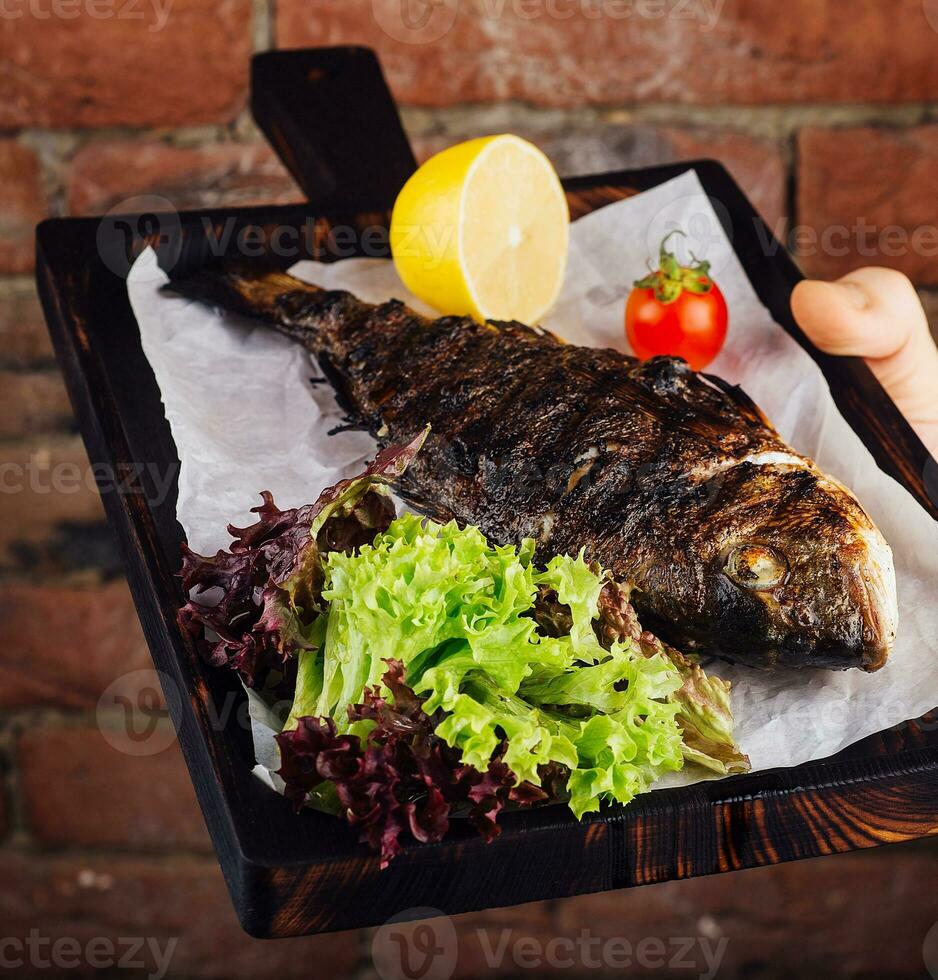 Served fried carp on wooden board photo