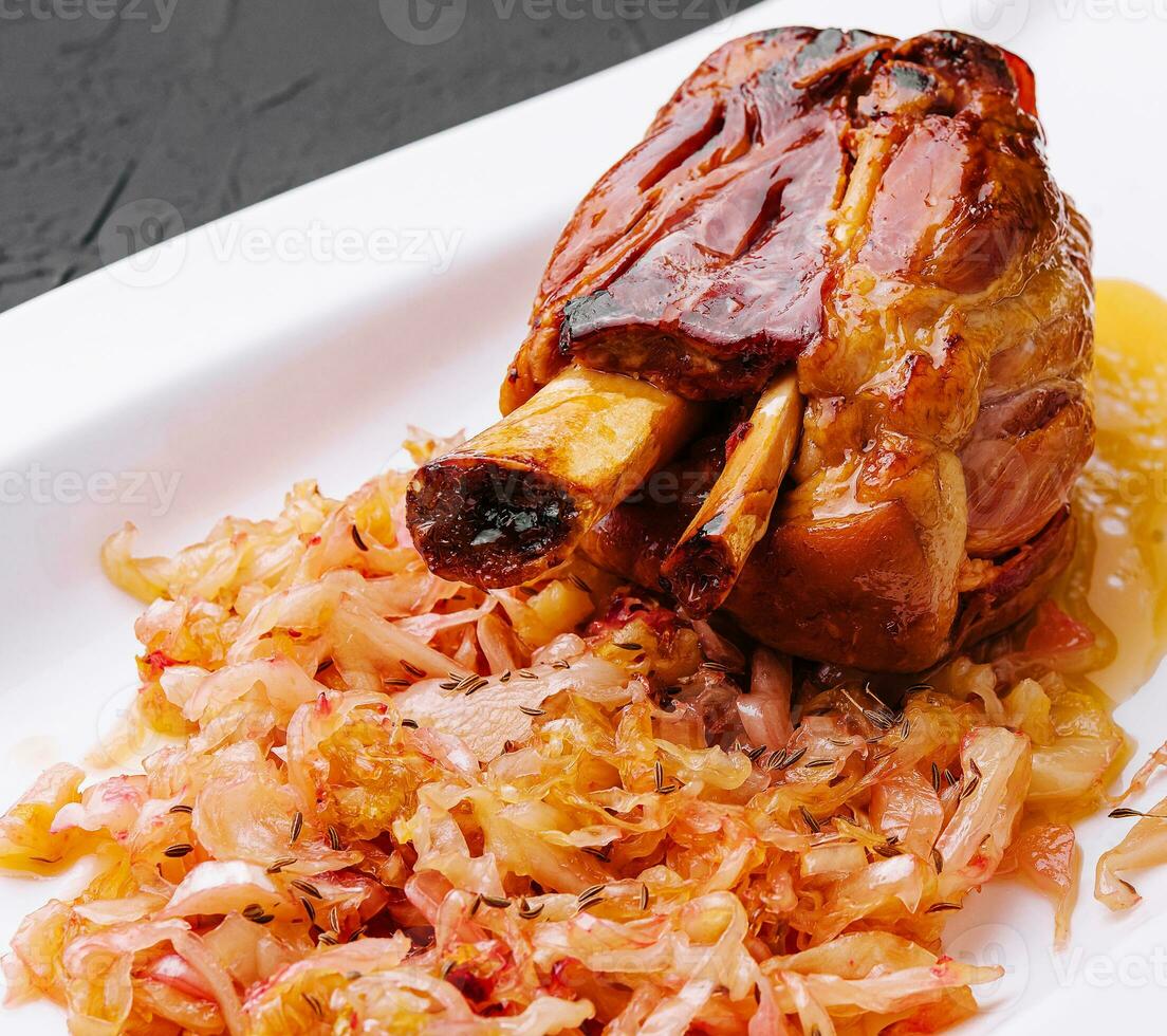 Bavarian pork knuckle with sauerkraut on plate photo