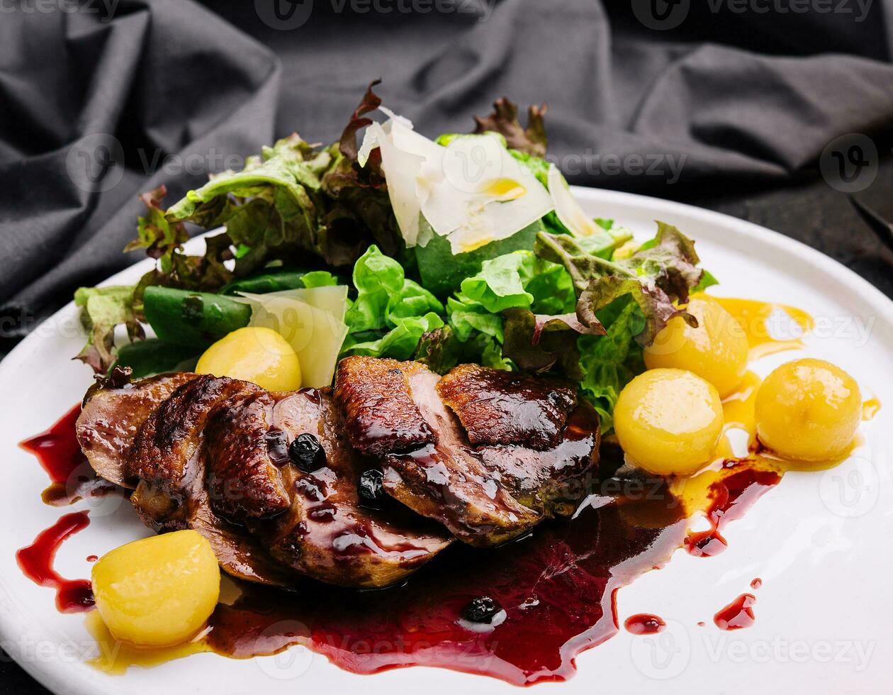 Modern style gourmet duck breast filet with salad and cranberry relish offered photo