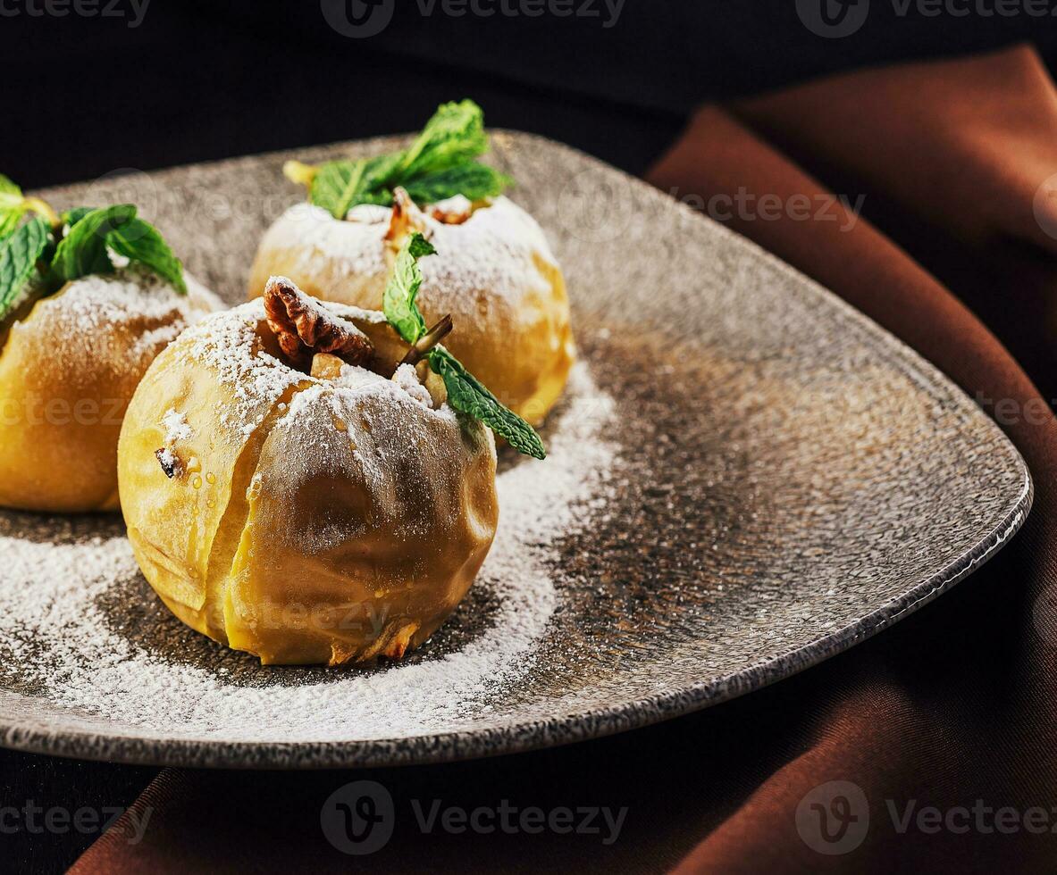 Baked apples stuffed with walnuts on plate photo