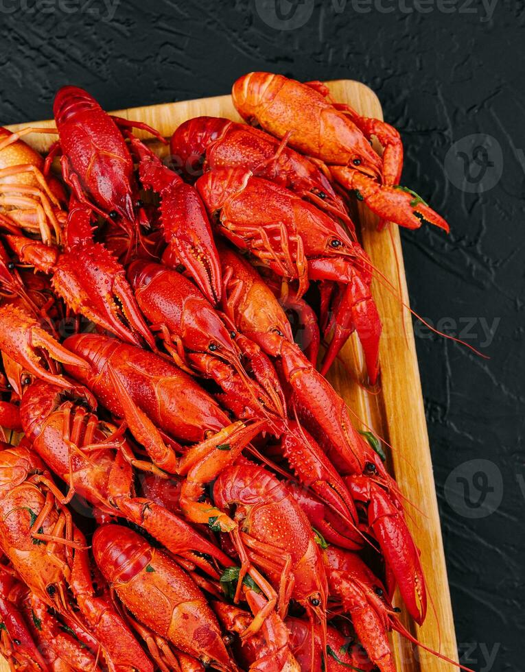 Fragrant boiled crayfish on a wooden board photo