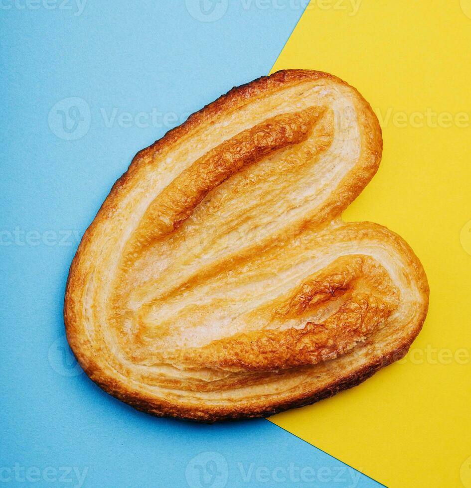 Puff pastry cookies on blue and yellow background photo