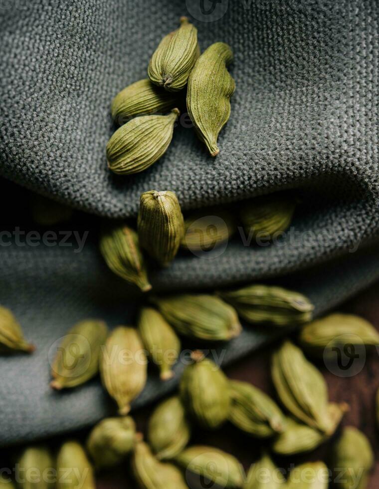 Green aromatic cardamom on fabric close up photo
