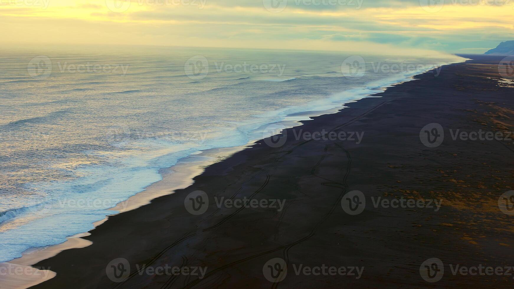 Nordic coastline with black sand beach and beautiful landscape panoramic view, ocean waves. Icelandic scenery with spectacular beach with stones and tides, arctic paradise. Handheld shot. photo