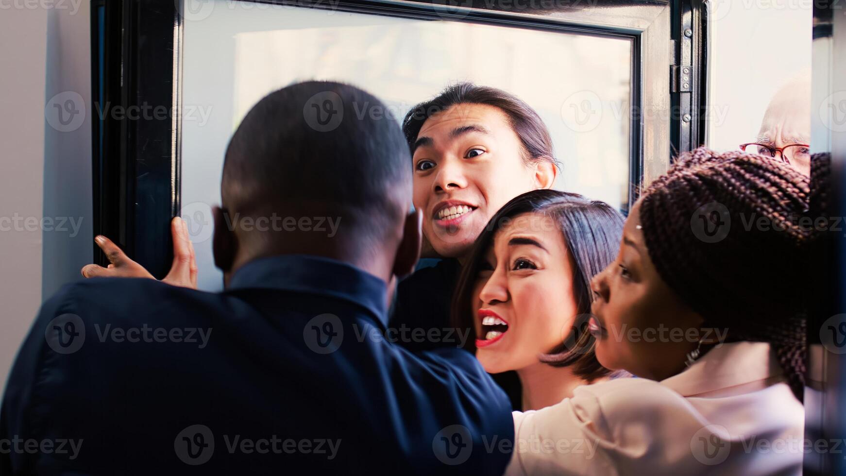 Security guard asking crowd to remain calm during black friday sales event, pushing people back and controlling clothing store entrance. Obsessed customers hunting for bargains, madness. photo