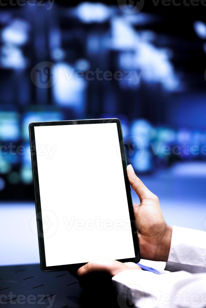 Repairman using mock up tablet to fix servers helping businesses manage databases and store files. Professional monitoring data center rackmounts used for high performance computing, close up photo