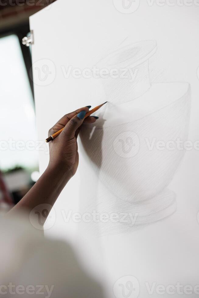 Close up of female hand holding pencil learning to draw and sketch while studying at art school. People expressing themselves through drawing, creative hobbies and mental health photo