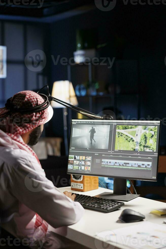 Arab male filmmaker working with footage and sound, editing a new project, and producing a film montage. A closeup of a Muslim man working on postproduction software on a computer. photo