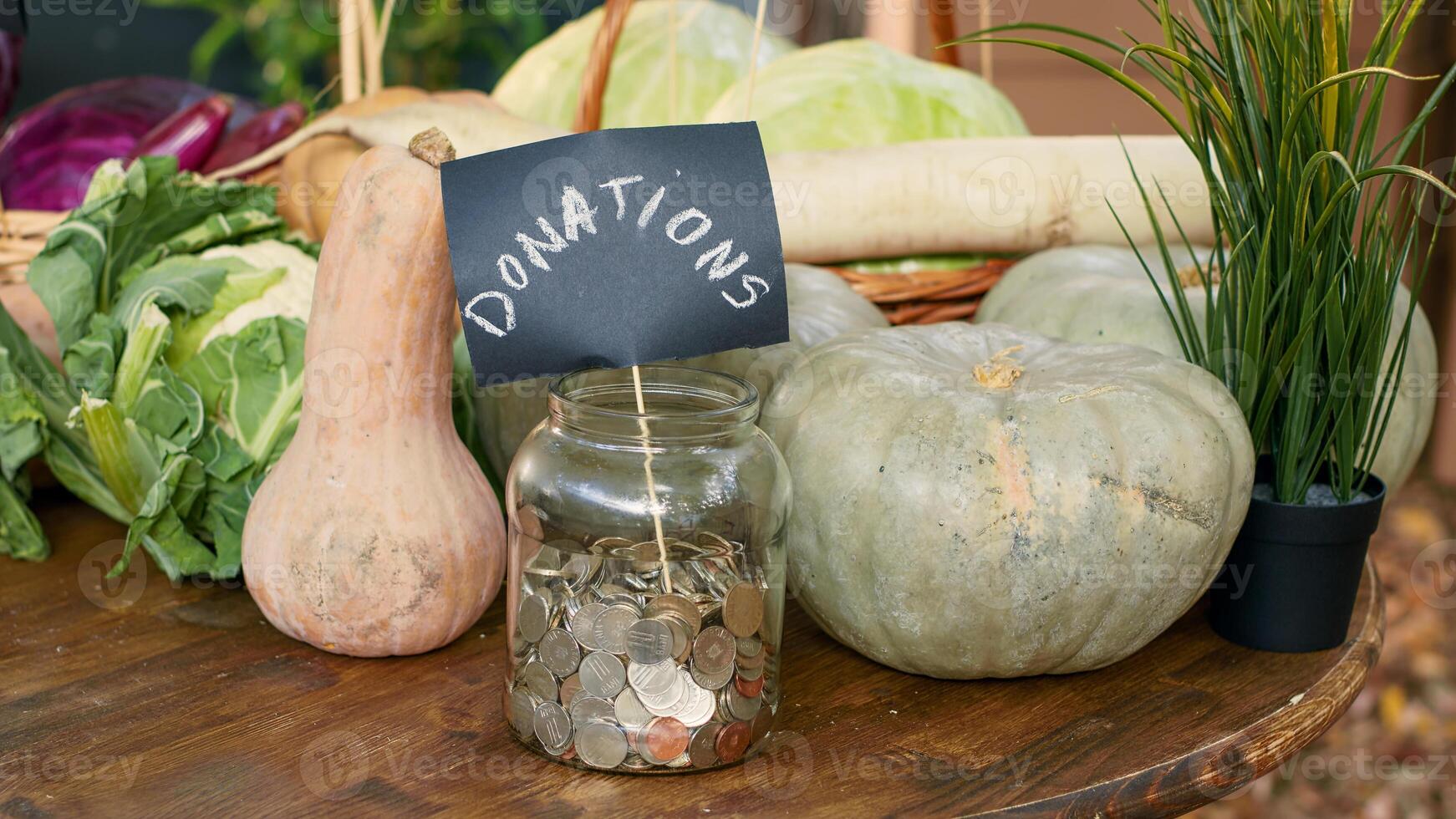 Table with homegrown vegetables and bottles of wine, jar filled with coins for local donations. Greenmarket stall with organic eco lettuce or cabbage, raw pumpkin and zucchini. Close up. photo