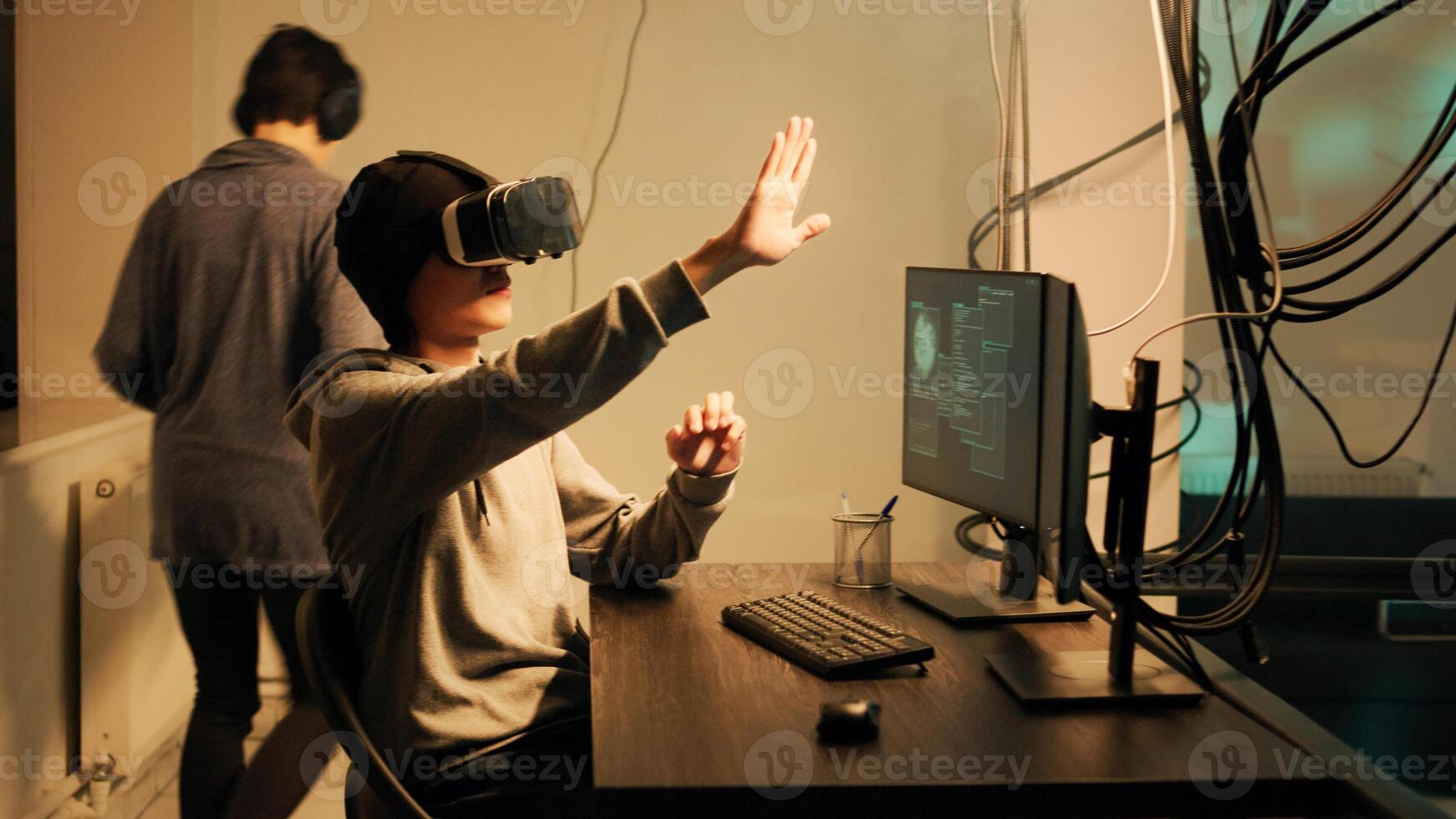 Cyber criminal working with 3d vr glasses to crack firewall encryption, using virtual reality headset to hack government system. Male hacker breaking network with malware and virus. photo