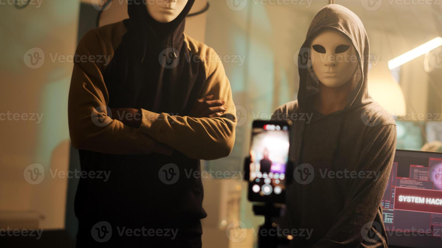 equipo de enmascarado hackers radiodifusión En Vivo amenaza video, preguntando para contraseñas Secuestro de datos en lugar de fugas datos. personas con de miedo mascaras amenazante a exponer gobierno información. Mano disparo. foto