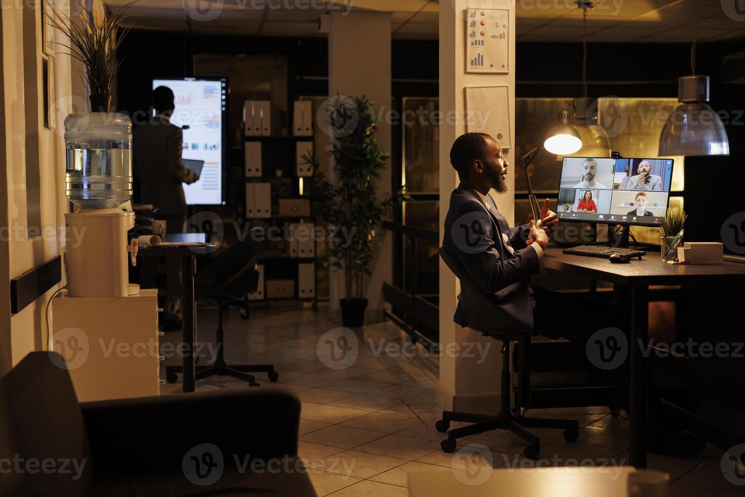 Businessman having online discussion with remote team, discussing marketing statistics during videocall meeting conference. Diverse colleagues working overhours at business strategy photo