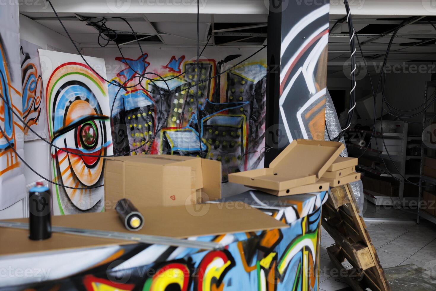 Messy decaying warehouse with spray paint art on walls in rusty abandoned place, old neglected space with chaos and debris. Destroyed deserted building in urban ghetto, crumbling structure. photo