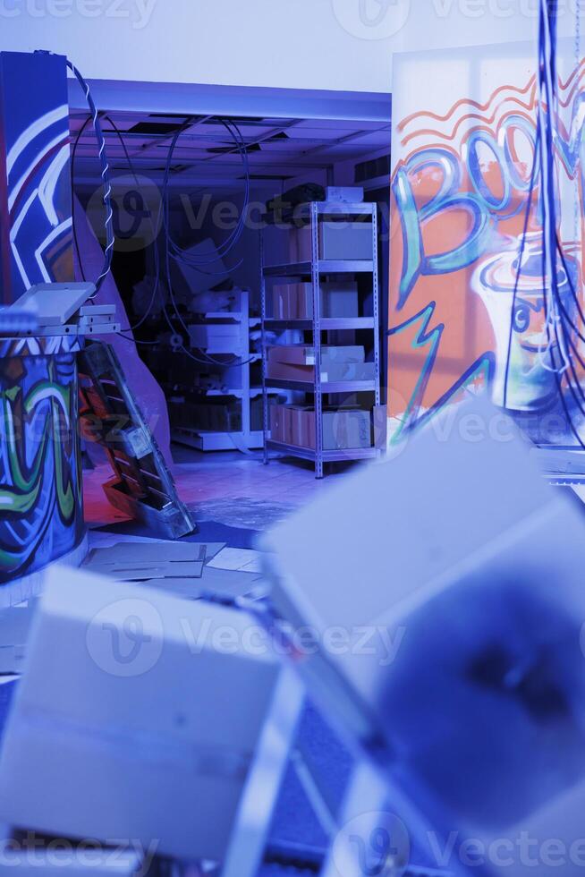 Damaged space filled with fluorescent neon lights, urban ghetto place with graffiti spray paint and purple bright light. Empty old abandoned building being illuminated and neglected. photo