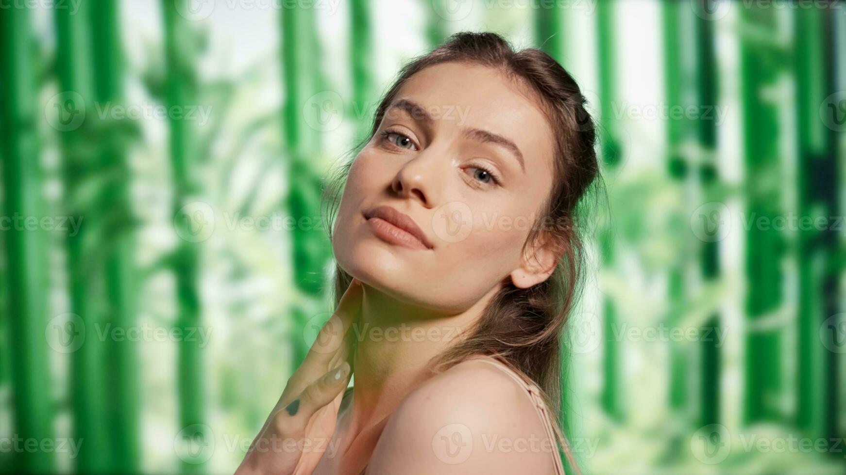 joven amable mujer posando terminado bambú arboles fondo, promoviendo belleza productos cosméticos para protección de la piel anuncio campaña. positivo confidente dama publicidad luminoso y radiante mirar, cuidado del cuerpo productos foto